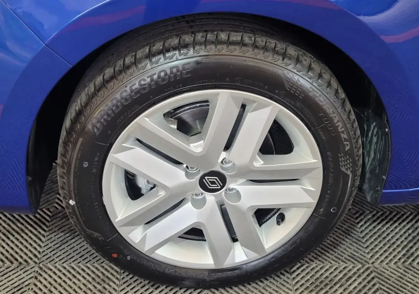 Gros plan sur la roue avant gauche d'une Renault Clio bleu 2025 avec jante argentée et pneu Bridgestone.