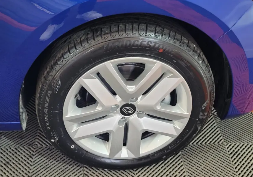 Gros plan sur la roue avant droite d'une Renault Clio bleu 2025 avec jante alliage et pneu Bridgestone.