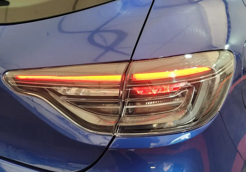 Feu arrière droit allumé sur Renault Clio Evolution Blue dCi 100 bleu, vue rapprochée du coffre et aile arrière.