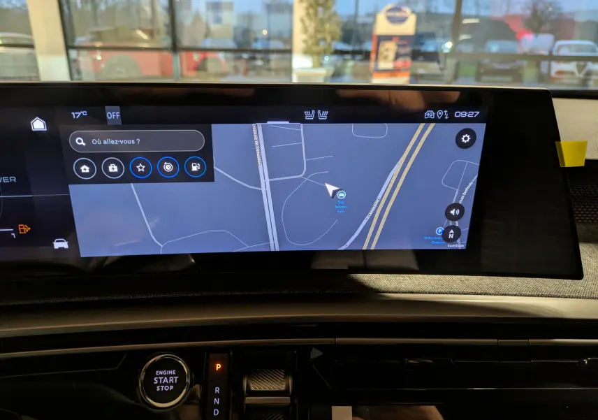 Vue intérieure du tableau de bord du Peugeot 3008 Hybrid 145 GT 2025, écran tactile de navigation allumé.