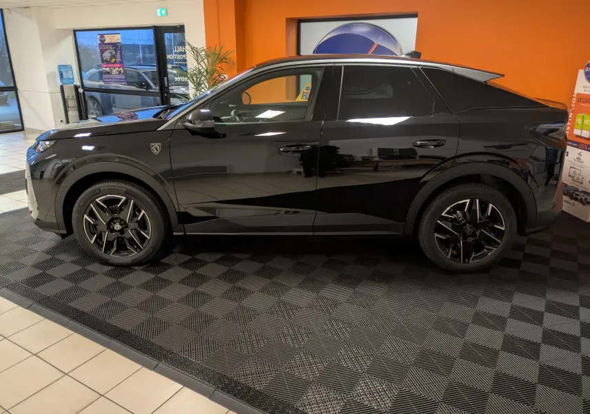 Vue latérale droite d'un Peugeot 3008 Hybrid 145 noir, avec jantes alliage 19'' et vitres arrière surteintées en showroom.