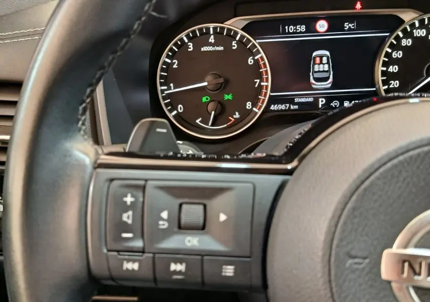 Gros plan sur le combiné d'instruments et le volant cuir noir du Nissan Qashqai 2022, affichage digital et commandes au volant.