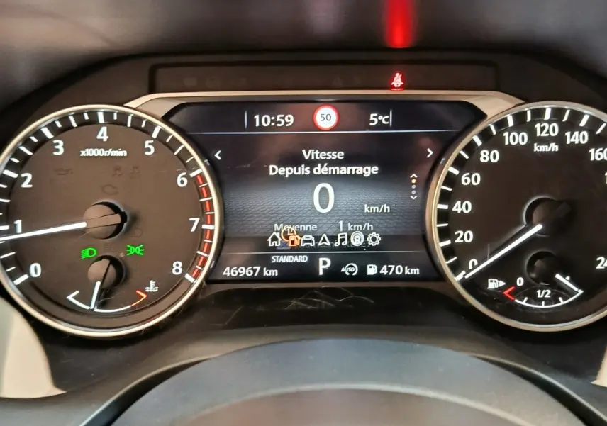 Tableau de bord du Nissan Qashqai 2022, affichage numérique central avec compte-tours et vitesse en km/h, éclairage vert allumé.
