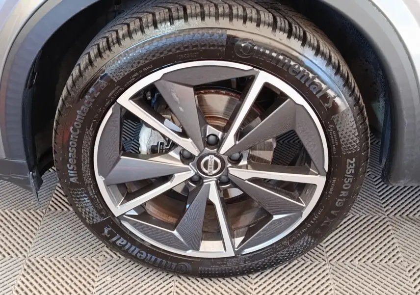 Gros plan sur la roue avant droite du Nissan Qashqai gris foncé, avec jante alliage et pneu Continental.