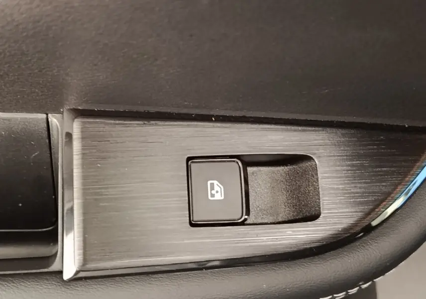 Bouton de commande de lève-vitre électrique sur panneau de porte intérieur noir du Nissan Qashqai gris foncé 2022.