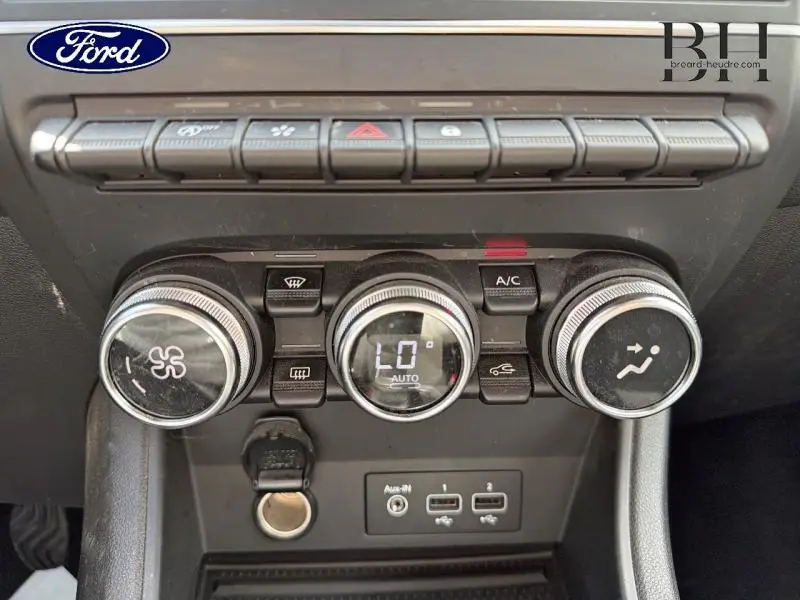 Détail du tableau de bord avec commandes de climatisation et ports USB du Renault Captur gris Cassiopée, vue frontale rapprochée.