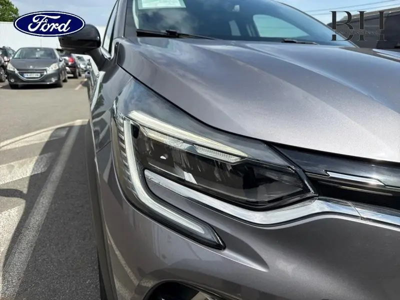 Gros plan sur le phare avant droit du Renault Captur gris Cassiopée 2022 avec lignes LED distinctives.