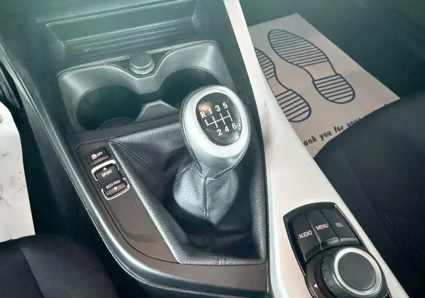 Gros plan sur la boîte manuelle et la console centrale noire et blanche de la BMW Série 1 2016.