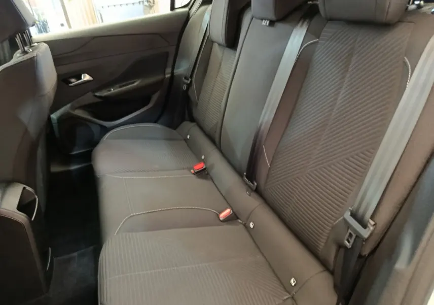 Vue intérieure montrant la banquette arrière noire de la Peugeot 308 2024, avec ceintures et appuie-têtes visibles.