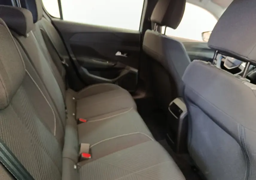 Vue intérieure arrière côté gauche montrant les sièges tissu gris foncé de la Peugeot 308 2024.