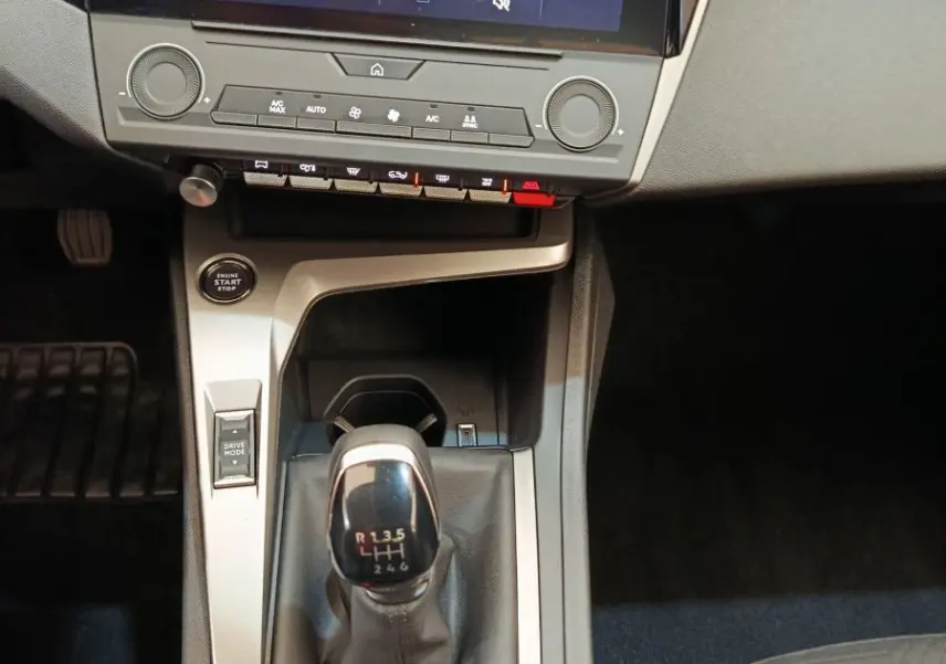 Vue intérieure centrée sur la console centrale de la Peugeot 308 blanche 2024 avec boîte manuelle et écran tactile 10 pouces.