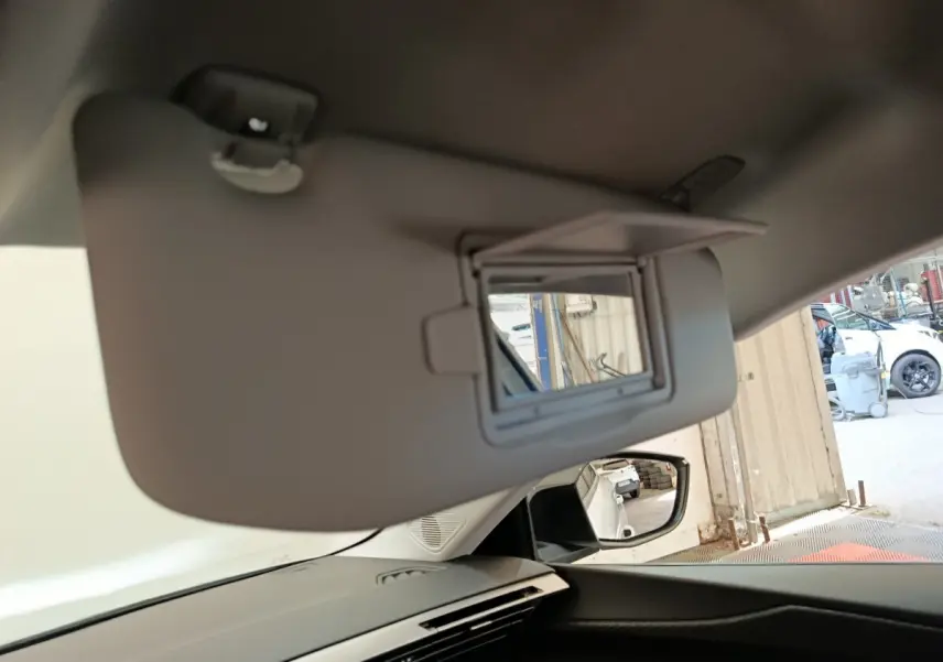 Détail du pare-soleil avec miroir intégré côté conducteur dans le blanc intérieur d'une Peugeot 308 2024.