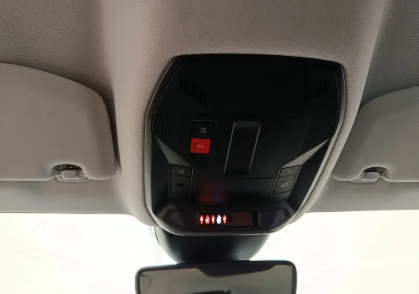 Vue intérieure du plafond avant de la Peugeot 308 blanche 2024, avec bouton SOS et éclairage de sécurité rouge.