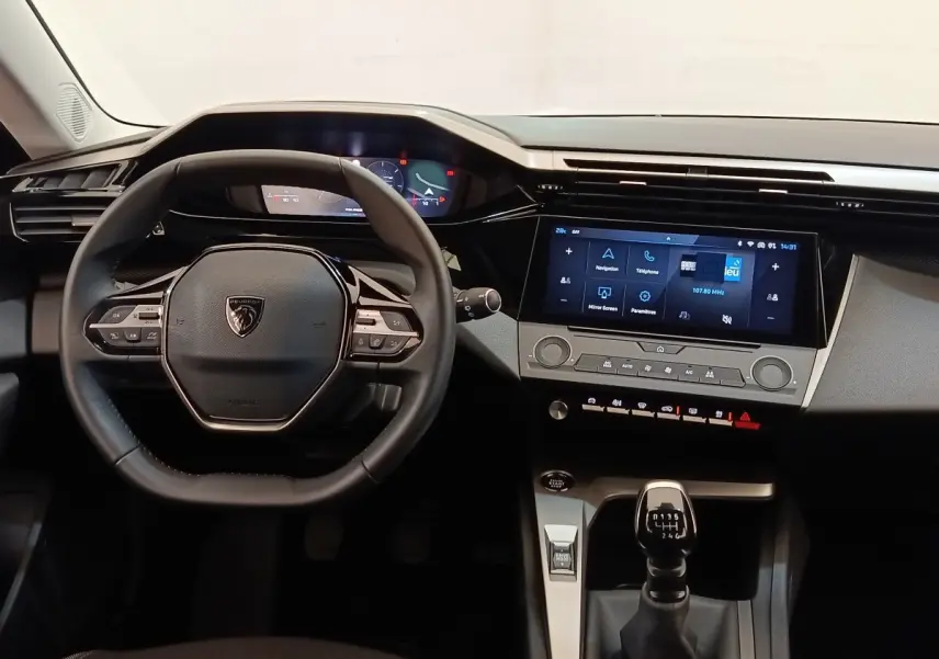 Vue intérieure centrée sur le volant cuir multifonctions et la console avec écran tactile de la Peugeot 308 2024.