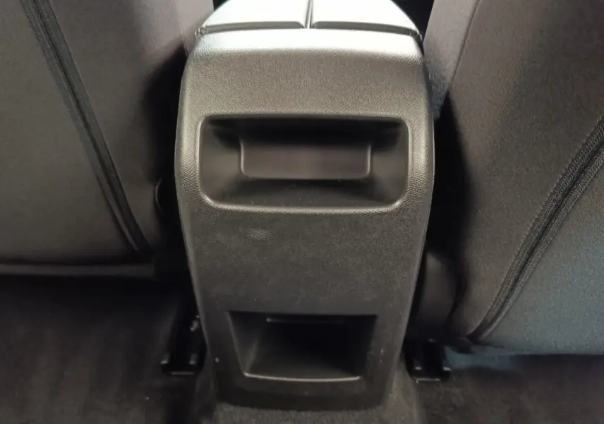 Détail de la console centrale arrière noire entre les sièges arrière d'une Peugeot 308 blanche 2024.