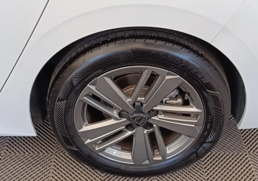 Gros plan sur la roue arrière droite d’une Peugeot 308 blanche avec jante alliage et pneu Goodyear.