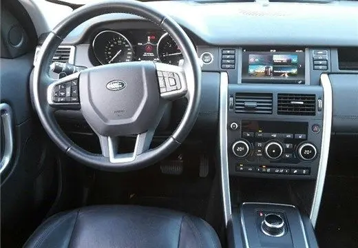 Vue intérieure du Land Rover Discovery Sport Mark II 2017, tableau de bord et volant en cuir noir avec commandes intégrées.