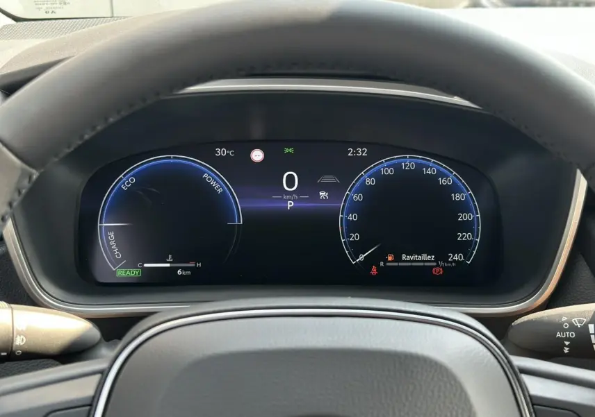 Tableau de bord numérique de la Toyota Corolla Touring Sport 1.8 Hybrid 140 Sport vue depuis le volant, affichage clair et moderne.