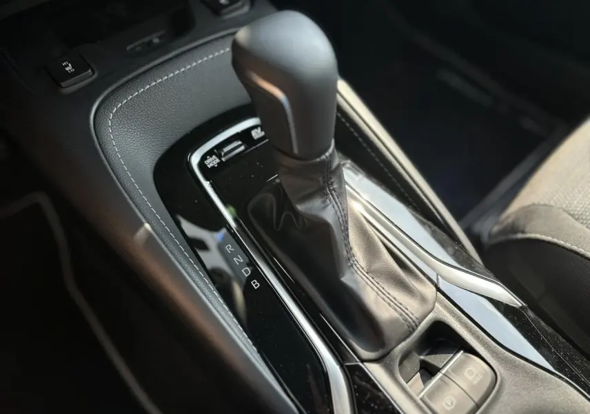 Le levier de vitesses automatique noir de la Toyota Corolla Touring Sport 1.8 Hybrid 2025 vu en gros plan côté conducteur.