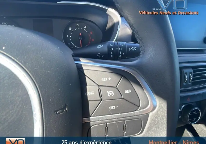 Gros plan sur le volant de la Fiat Tipo Station Wagon Business 2018, montrant les commandes de régulateur de vitesse.