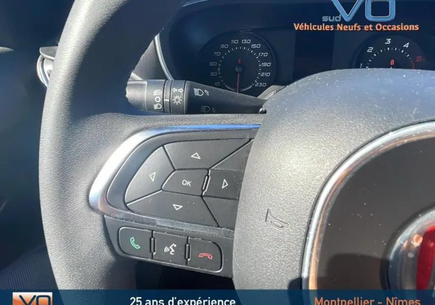 Gros plan sur le volant multifonction noir du Fiat Tipo Station Wagon gris, avec commandes audio et téléphone intégrées.