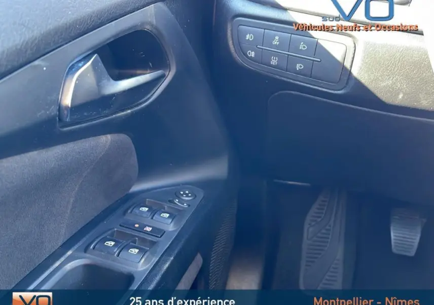 Détail des commandes de porte côté conducteur de la Fiat Tipo gris, avec boutons de vitres électriques et réglages des rétroviseurs.