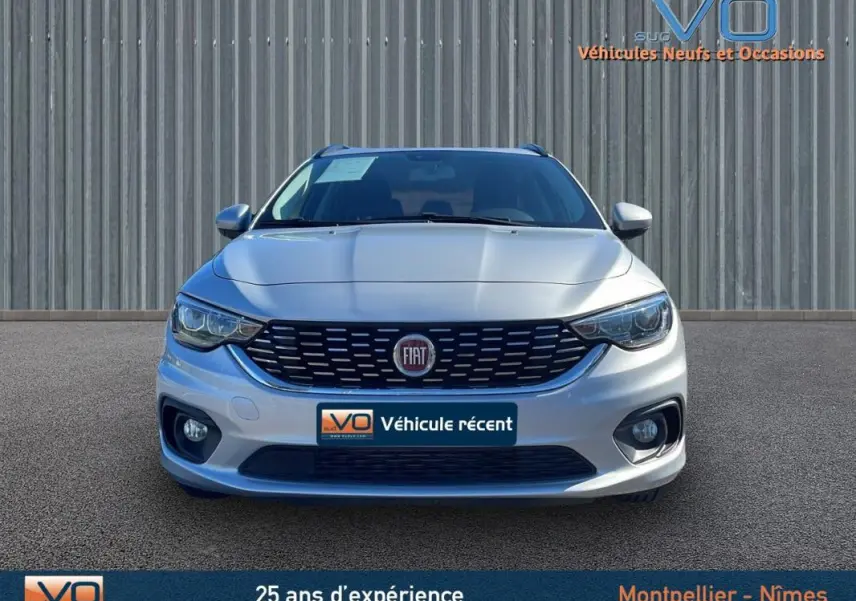 Vue frontale d'un FIAT Tipo gris avec calandre noire et phares antibrouillard visibles sur un fond neutre.