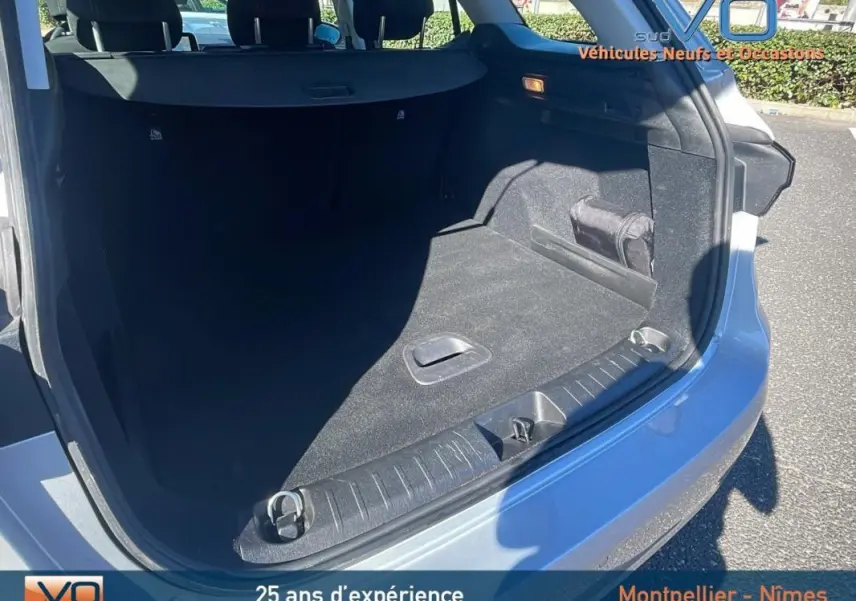 Coffre ouvert vu de l'arrière droit d'un FIAT TIPO gris avec barres de toit et jantes alliage 16 pouces.