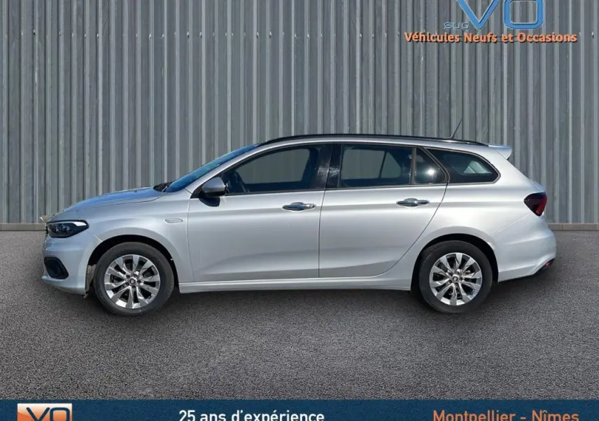 Profil côté gauche d'une FIAT TIPO Station Wagon gris métallisé, avec jantes alliage et barres de toit visibles.