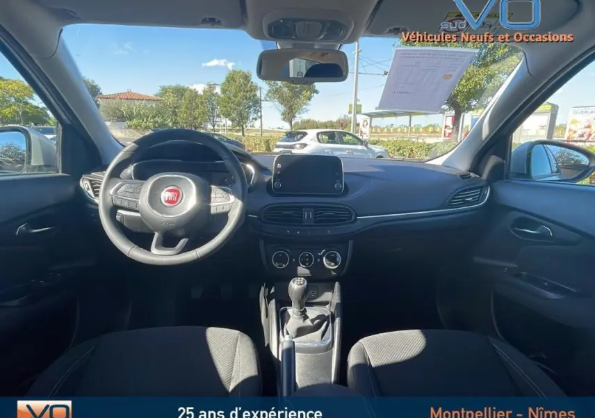 Intérieur noir de la Fiat Tipo Station Wagon 2018, vue frontale du tableau de bord avec volant et écran tactile.