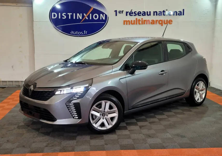 Renault Clio gris foncé vue 3/4 avant droit avec feux LED et jantes alliage dans un showroom.