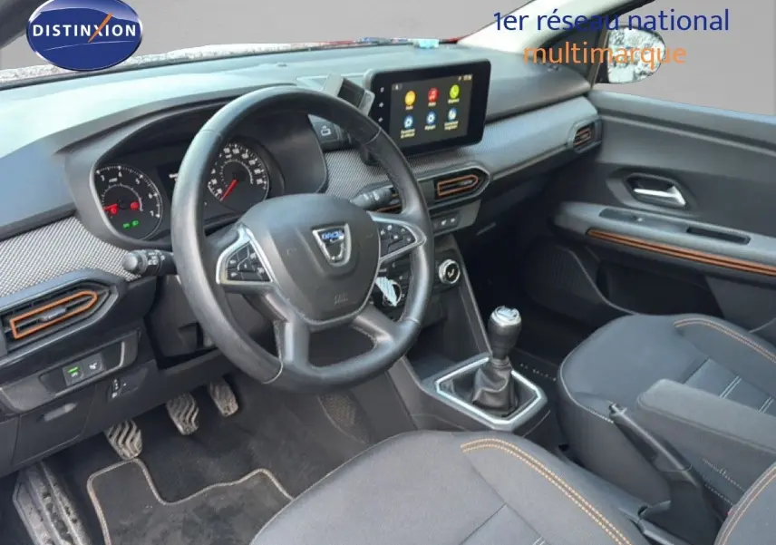 Vue intérieure côté conducteur de la Dacia Sandero Stepway 2021, tableau de bord moderne avec écran tactile et volant multifonction.