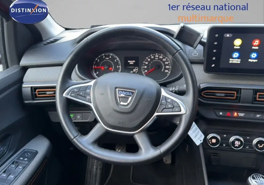 Vue intérieure centrée sur le volant noir de la Dacia Sandero Stepway 2021 avec tableau de bord et écran tactile.