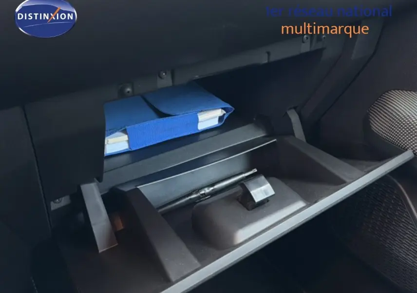 Gant de boîte à gants ouvert avec un carnet bleu et un stylo à l'intérieur d'une Dacia Sandero Stepway 2021.
