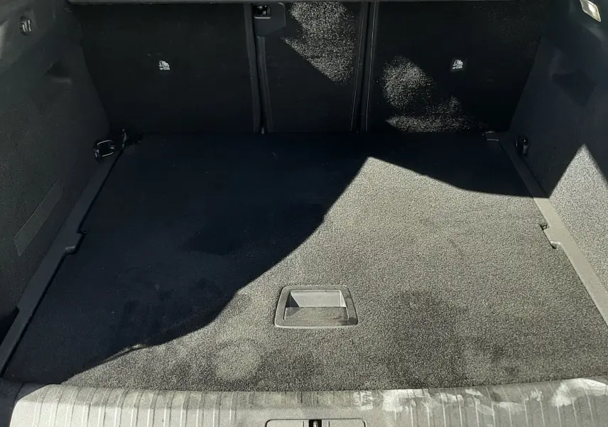 Coffre ouvert vu de l'arrière d'un Peugeot 3008 blanc Okenite, espace de chargement propre et vide.