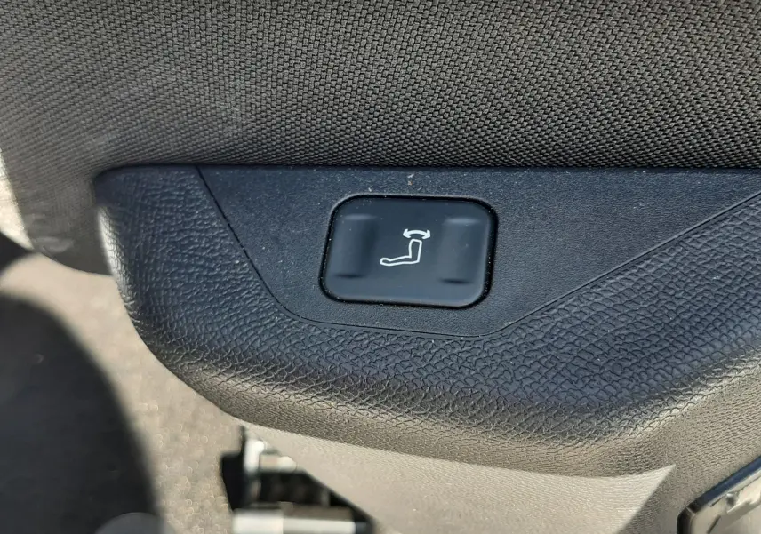 Bouton de réglage électrique du siège en gros plan à l'intérieur du Peugeot 3008 blanc Okenite 2024.