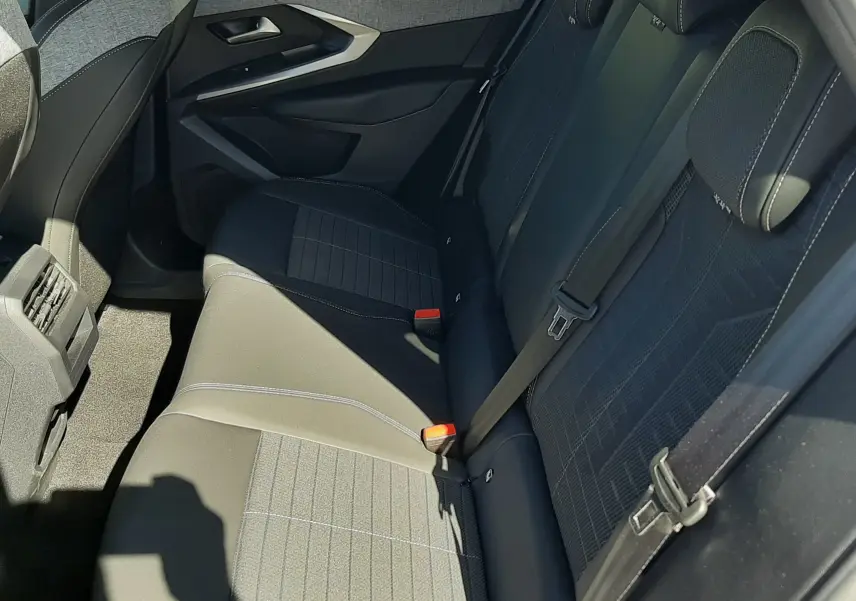 Vue intérieure côté droit des sièges arrière noirs avec surpiqûres blanches du Peugeot 3008 Hybrid 2024.