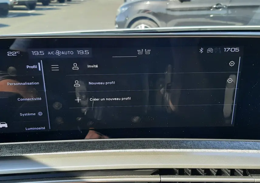 Écran tactile du tableau de bord du Peugeot 3008 Hybrid 145, affichant les profils utilisateur, avec vue partielle de la console.