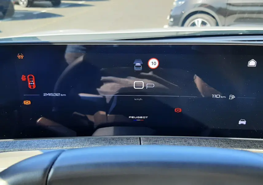 Vue intérieure du tableau de bord numérique du Peugeot 3008 Hybrid 2024, avec affichage digital et volant en premier plan.