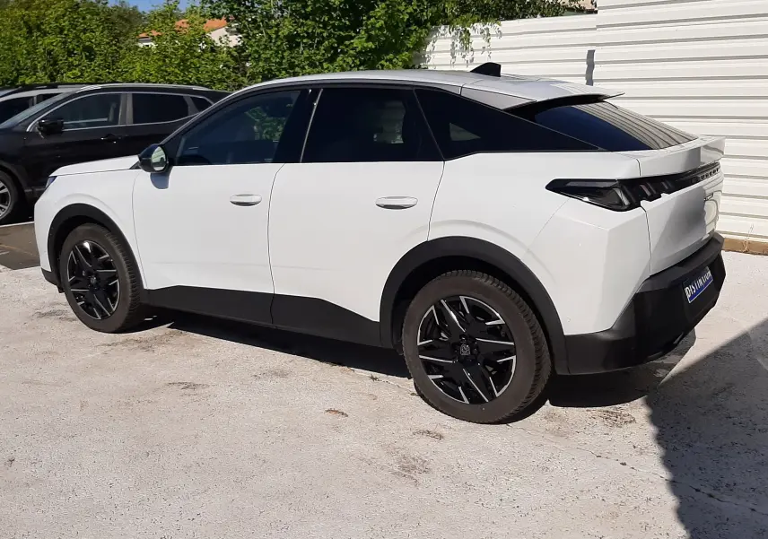 Peugeot 3008 hybride blanc Okenite vu de côté gauche arrière, avec toit noir et jantes noires distinctives.