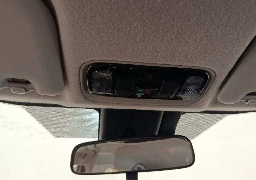 Plafonnier avec commandes intégrées et rétroviseur intérieur dans une Toyota Yaris hybride gris clair, vue de l'habitacle.