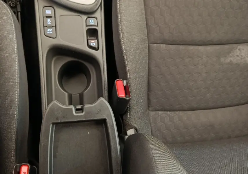 Vue plongeante sur la console centrale et siège avant droit gris foncé de la Toyota Yaris hybride 2022, avec levier de vitesse automatique.