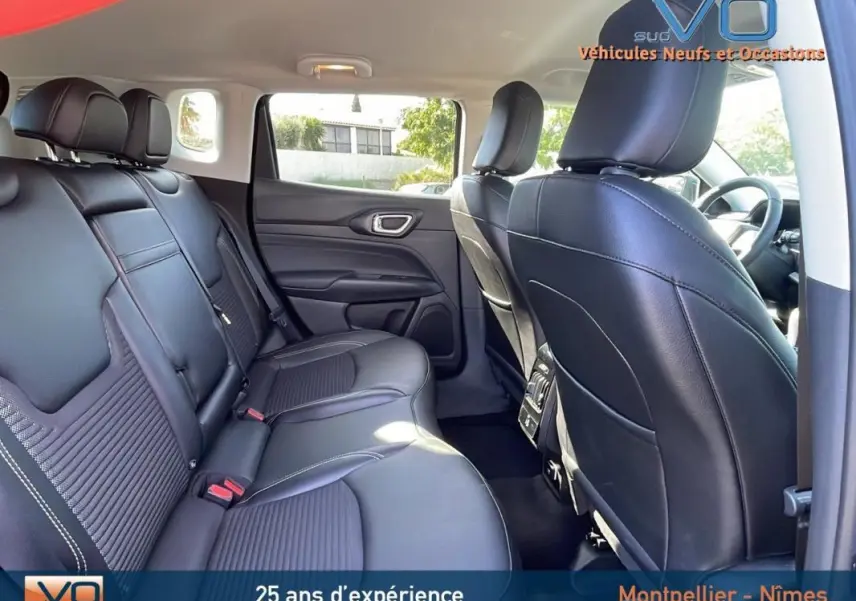 Vue intérieure arrière du Jeep Compass 2023 noir avec sièges cuir noirs et accoudoir central arrière visible