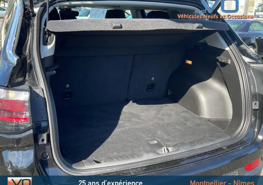 Coffre ouvert du Jeep Compass noir 2023 vu de l'arrière, montrant un espace de chargement propre et spacieux.