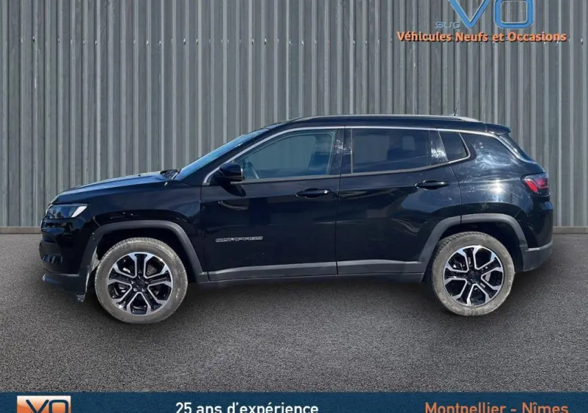 Profil côté gauche d'un Jeep Compass noir 2023 avec jantes 18 pouces, barres de toit et rétroviseurs électriques rabattables.