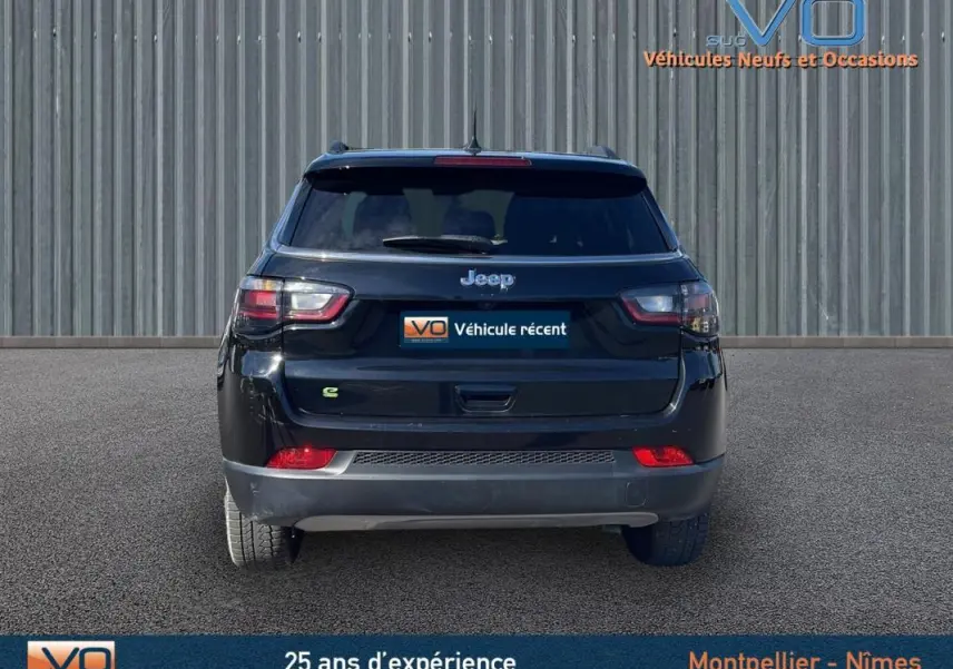 Vue arrière d'un Jeep Compass noir 2023 avec feux LED et logo e-Hybrid sur un sol goudronné.