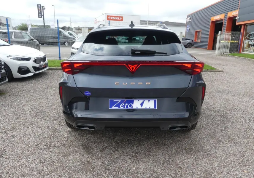 Vue arrière d'un CUPRA Formentor gris Graphene avec feux arrière en bandeau lumineux et double sortie d'échappement noire.