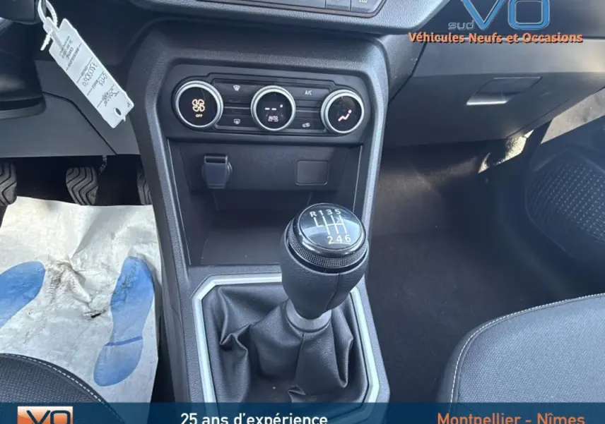 Gros plan sur le levier de vitesses manuel noir et la console centrale du Dacia Jogger gris 2025, intérieur moderne et fonctionnel.