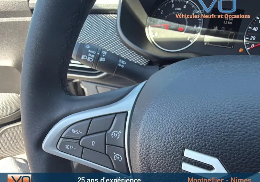 Gros plan sur le volant noir du Dacia Jogger gris 2025, avec commandes intégrées pour régulateur de vitesse.