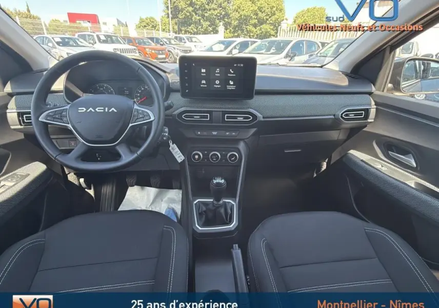 Intérieur du Dacia Jogger 2025 essence, vue avant sur le tableau de bord et volant multifonction noir.